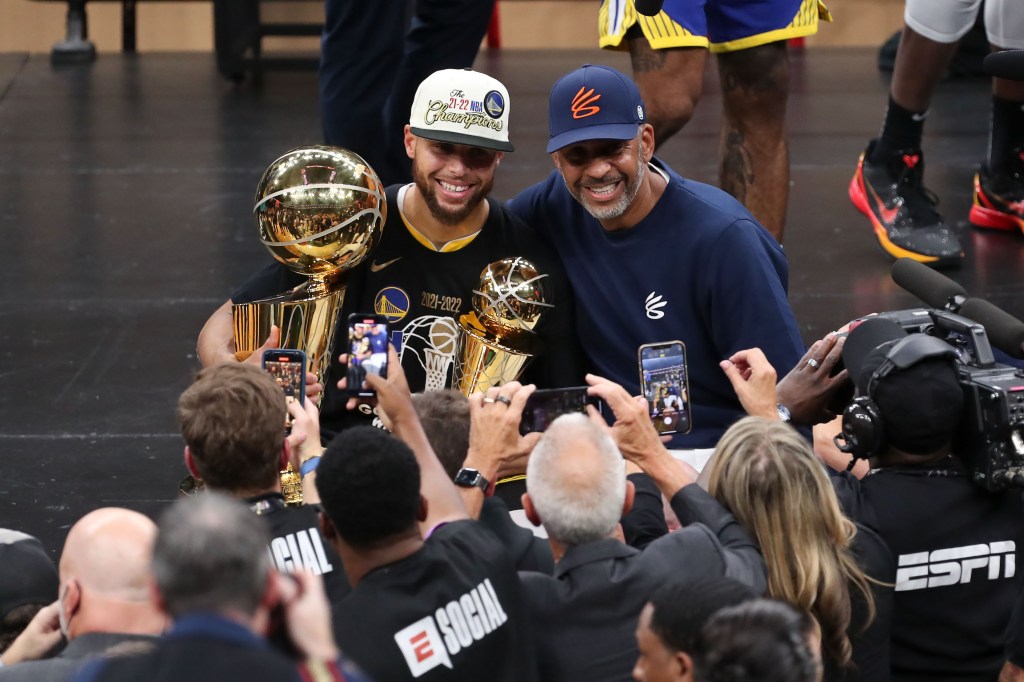Jun 16, 2022; Boston, Massachusetts, USA; Golden State Warriors guard Stephen Curry (30) and his father Dell Curry pose with the Larry O'Brien Trophy after defeating the Boston Celtics in game six of the 2022 NBA Finals at the TD Garden. Mandatory Credit: Paul Rutherford-Imagn Images
